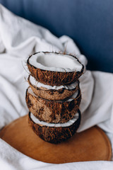 Coconuts. Ripe coconuts lie on a wooden tray. Organic product. Broken coconut. Composition of coconuts.