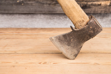 Old ax with a wooden handle stuck in wooden log. Concept for woodworking or deforestation....