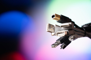 A lot of usb wires. A bunch of wires on a colored background.