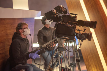 masked cameraman is filming a television show in the studio