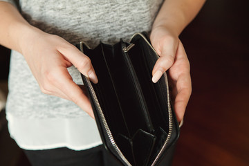 Woman with poor manicure holding empty wallet. Concept of poverty, economic crisis, coronavirus concept.