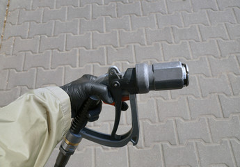 Driver's hand holding an LPG refueling gun.. LPG (liquefied petroleum gas) dispenser.