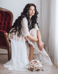 Beautiful brunette bride with stylish make-up in white underwear.Morning bride
