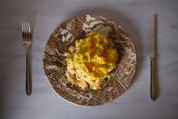 Creamy fish pie: various types of fish, creamy sauce and cheesy potato topping. Overhead horizontal image