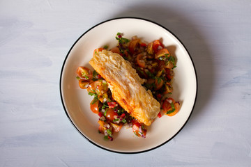 Pan fried cod fish with tomato salsa. View from above, top studio shot