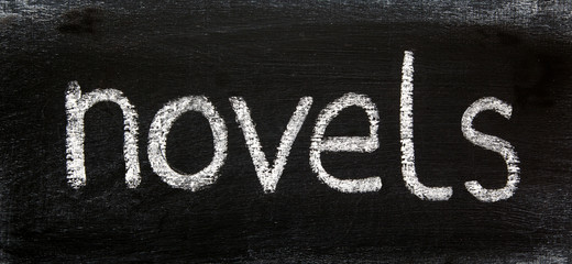 NOVELS - in a title word for literature, writing, books, authors, reading; & for education and teaching concepts & ideas - in panorama / header / banner, written in real chalk letters on a chalkboard.