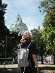Young female tourist standing on street and enjoying the view of beautiful architectural landmark