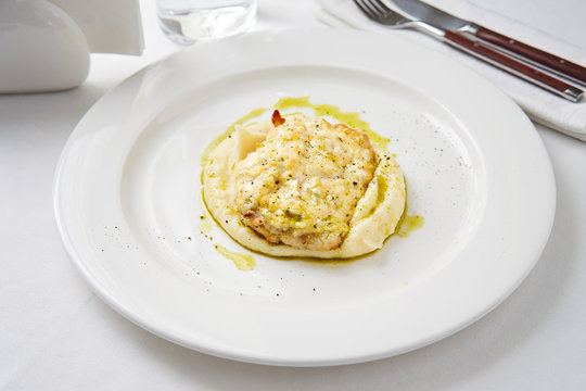 Baked cod fillet with mashed potatoes on white table