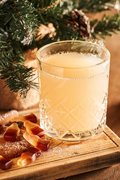 Hot mulled white wine cocktail served in a glass on wooden board