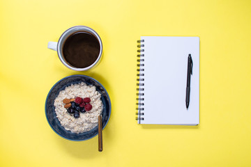 notepad with coffee and oatmeal blueberry banana bowl ready to start the day
