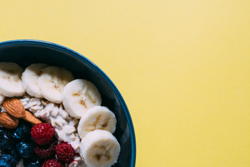 oatmeal blueberry banana bowl with yellow background