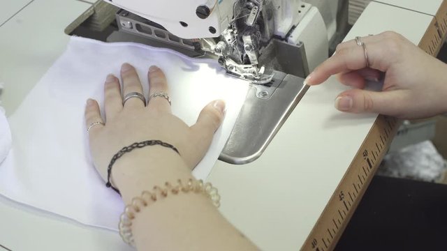 As part of the practice, the teenager throws quacks of fabrics on overlock, which are intended for protective masks for the hospital.