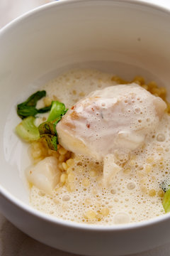 Fusion dish of baked cod with Beurre Blanc sauce, Israeli couscous and grilled vegetables