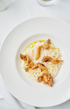 Creamy mascarpone risotto with oyster mushrooms on white table