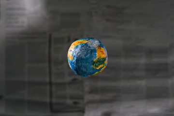 The concept of the world press. focus is the layout of the planet Earth on the background of a defocused blurred newspaper. The world of the press. World global press.