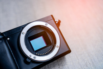 Close up Digital Camera APS-C Sensor and lens mount on grey background preparing for cleaning and maintenance concept. Copy space and background.
