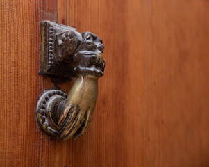 Bronze door knocker by the hand of Fatima, wooden background, copy-space, Marrakech, Morocco.