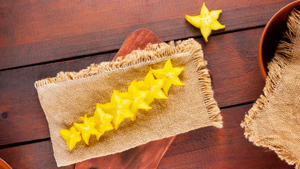 Carambola on the wooden board. Star Fruit (Averrhoa carambola L.) on burlap. Yellow fruit carambola...
