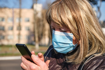 Caucasian elderly woman wears mask for protect coronavirus outbreak and use smartphone to talk with her family