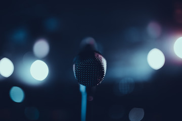 Microphone on stage with bokeh in the background. Isolated microphone. POV