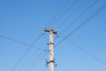Electric pole with electric wires on blue sky