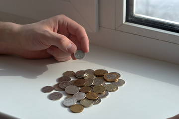 A man counts money and divides it. Round coins. 