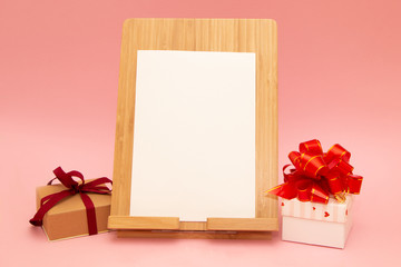 Obraz na płótnie Canvas Mother's Day, Women's Day or other suitable holiday card, photo frame with blank space for a text and gift box with red bow on pink background, stylized image
