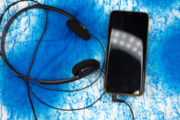 Smartphone and headset on a blue background