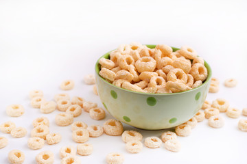 healthy cereal rings on a white background in a plate and scattered on the table. morning eat. Healthy breakfast. Dry muesli.