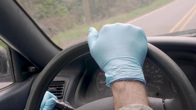Man switches on his lights while driving with protective gloves in slow motion