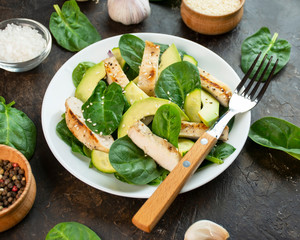 Grilled chicken breast with avocado and herbs on a dark background. Dietary nutrition. Healthy lifestyle. Side view. Close-up.