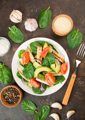 Grilled chicken breast with avocado and herbs on a dark background. Dietary nutrition. Healthy food. View from above.