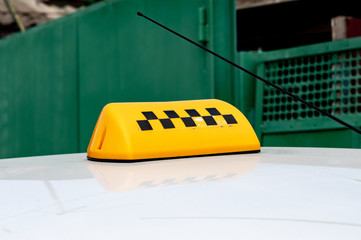 black-yellow checker taxi on a white car. permission to transport passengers. make money on delivery
