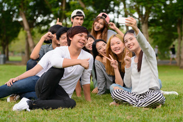 Happy young group of friends taking selfie together at the park