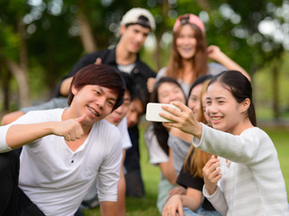 Happy young group of friends taking selfie together at the park