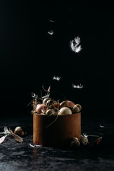 basket with chicken and quail eggs on a black background