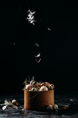 basket with chicken and quail eggs on a black background