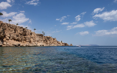 Fototapeta na wymiar Sharm el Sheikh red sea coastline. Beautiful coral coast. Blue sky with clouds. Background texture