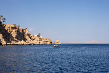 Sharm el Sheikh red sea coastline. High cliffs and a motorboat in the sea.