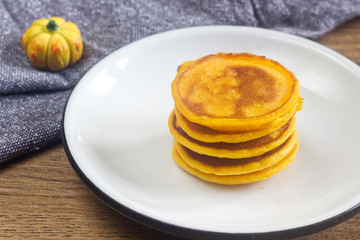 Homemade pumpkin pancakes on the white plate.