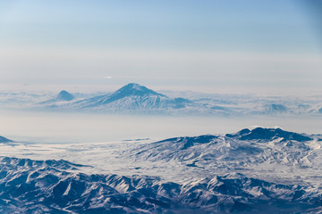 Fototapeta na wymiar Mount Ararat over the clouds. A view from the plane window.