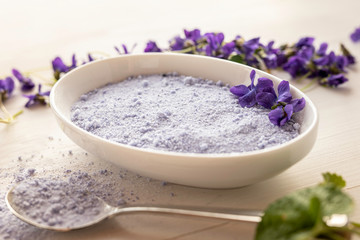 Obraz na płótnie Canvas viola violeta odorata violet natural sugar bath salt on white background in porcelain dish 