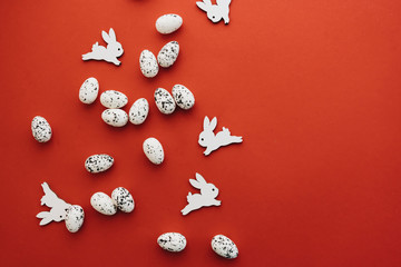 easter eggs and toy rabbits on red background