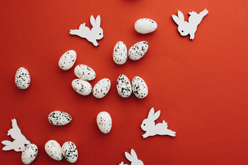 easter eggs and toy rabbits on red background