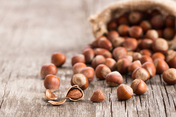 Hazelnuts, filbert in burlap sack on rustic wooden table. heap or stack of hazel nuts. Hazelnut background, healty food