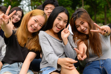 Happy young group of friends having fun together at the park