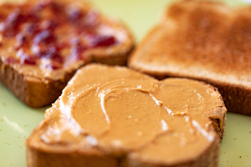 Fototapeta na wymiar Toasted whole wheat bread slices with peanut butter and jam