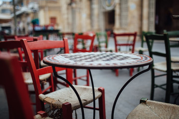 cafe table with chess board mosaic and chairs outdoors