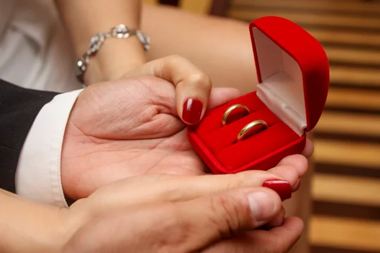 Fotka „Mãos de noivo e noiva segurando caixinha de alianças. Caixa vermelha  com anéis. Esposa e esposo com anel de noivado.“ ze služby Stock | Adobe  Stock