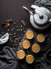 Indian chai in glass cups with metal kettle and other masalas to make the tea